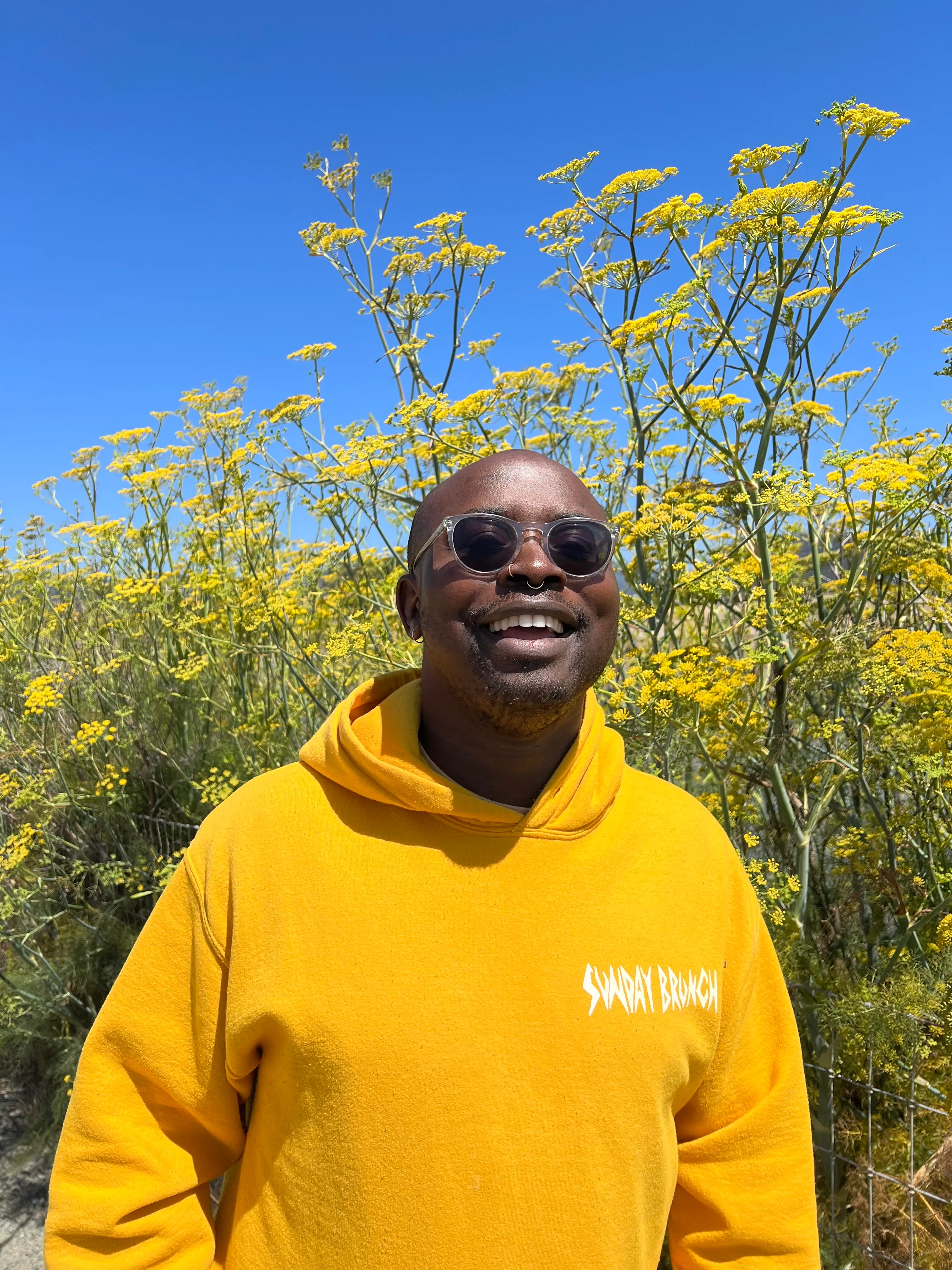 Portrait with yellow flowers while wearing a yellow sweatshirt